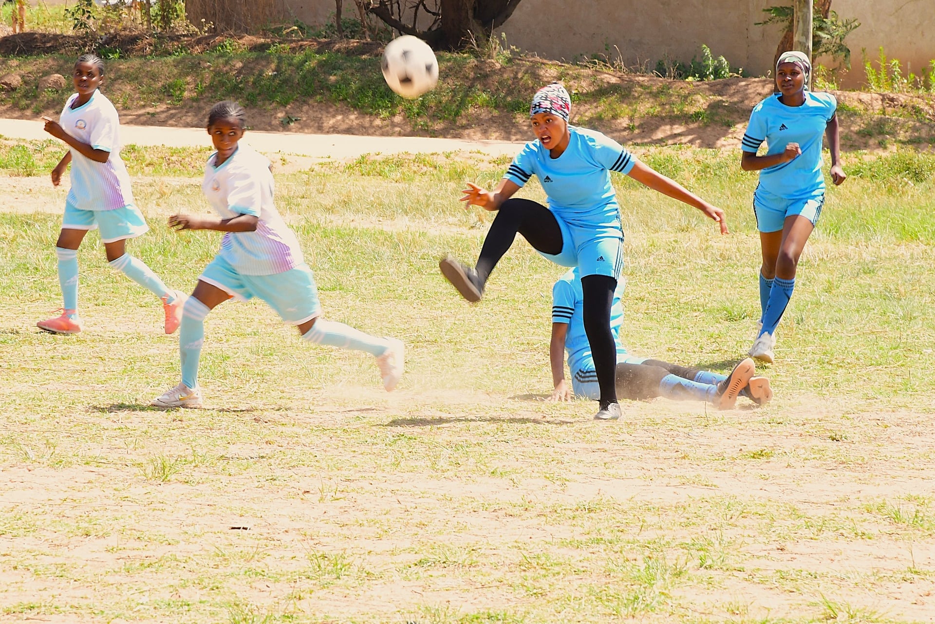Mpira Fursa players mid-game on a dusty Tanzanian school pitch